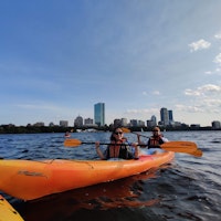 Frank kayaking with the city skyline in the background