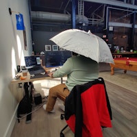 Frank wearing an umbrella hat in the office