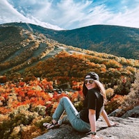 Jerrianne sitting on a rock overlooking the fall foliage