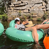 Jerrianne floating down the Saco River in a green tube