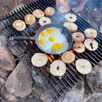 Cooking breakfast on the fire.