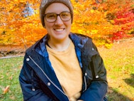 Steph smiling in front of the fall foliage